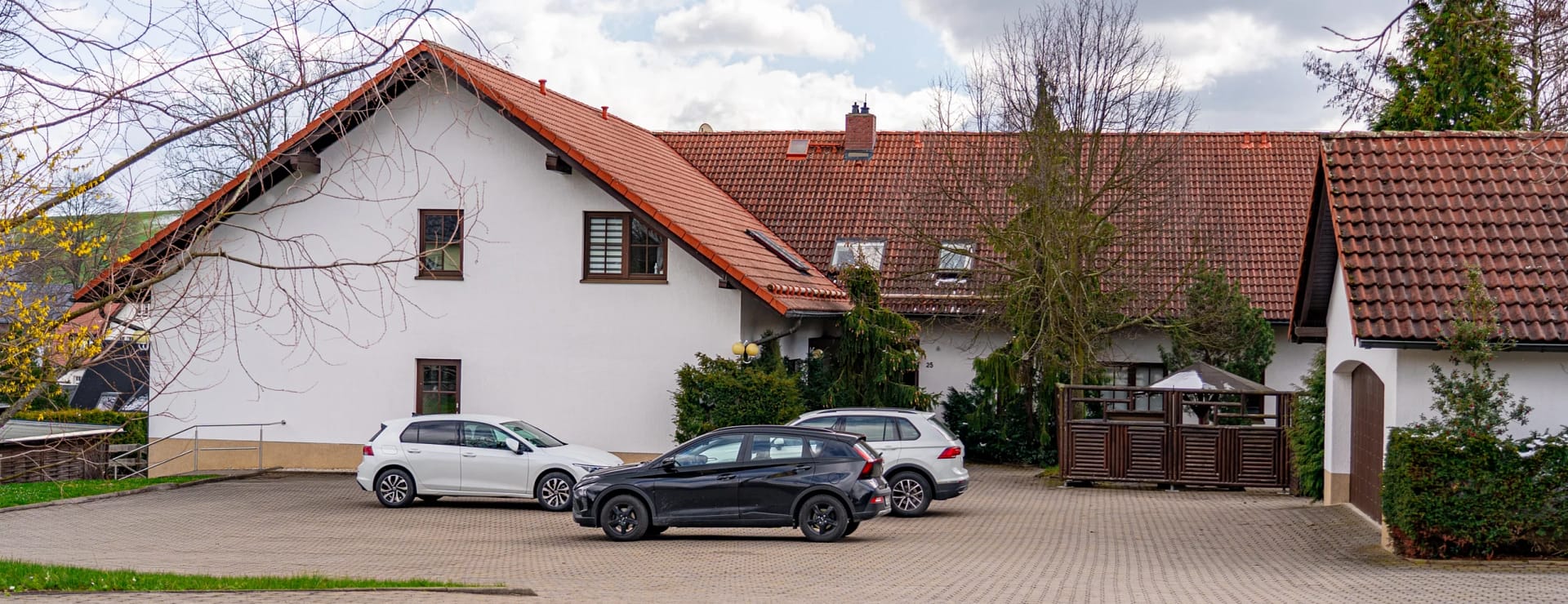 haus mit Parkplatz. Leicht unscharf. Abgedunkelt, da im hintergrund. 